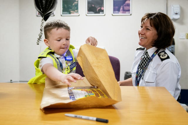 Boy and police officer at a table with a large brown envelope