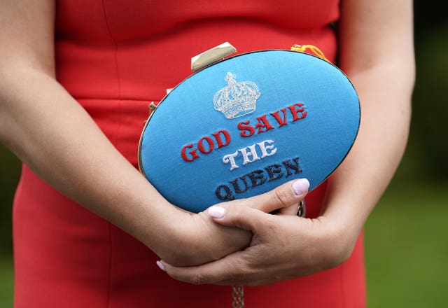 Racegoer Anna Gilder holds a God Save The Queen clutch bag on Ladies Day during the Derby Festival at Epsom Racecourse