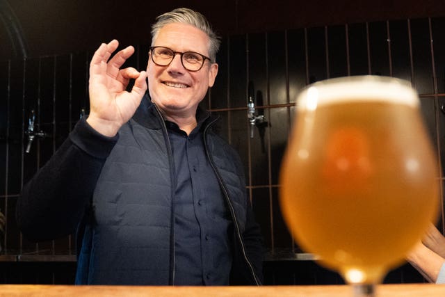 Labour Party leader Sir Keir Starmer helps to serve drinks during a visit to 3 Locks Brewery in Camden in north London