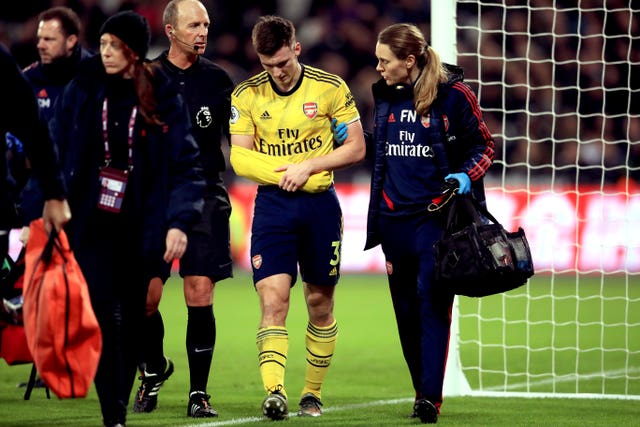 Kieran Tierney, centre, leaves the field injured against West Ham