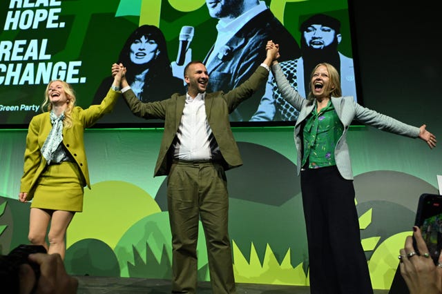 Green Party leaders take applause on stage 