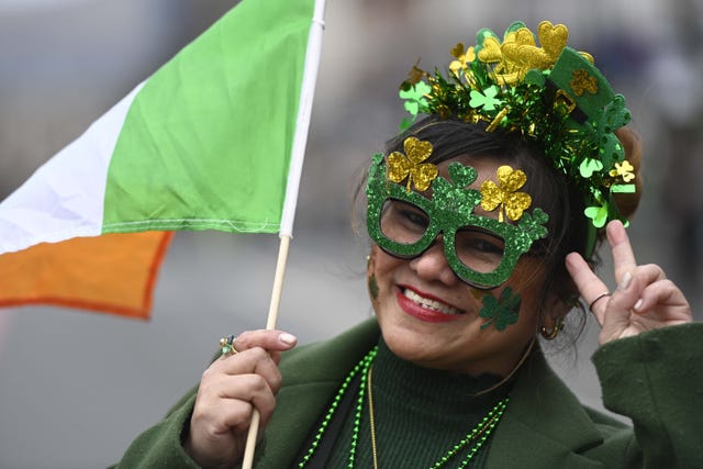A masked woman watches the parade in Belfast