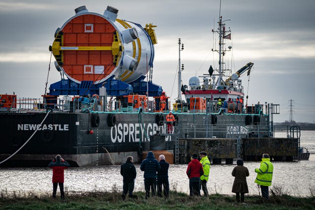 People watch as a new nuclear reactor arrives