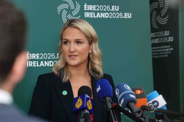 Helen McEntee speaking in front of a bank of microphones