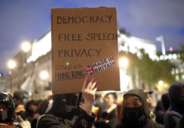 A person holding a placard reading 'Democracy, Free Speech, Privacy' during a Hong Kong democracy protest