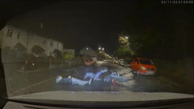 A screengrab shows the moment a e-bike is knocked over by a marked police car