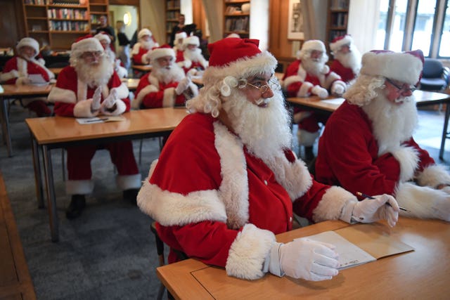 Father Christmas performers in a classroom during the 23rd annual Santa School at Southwark Cathedral
