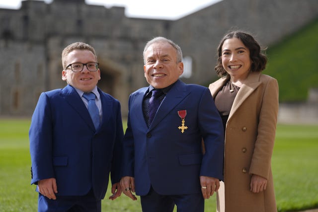 Actor Warwick Davis, centre, with his children Harrison, left, and Annabelle, standing in front of Windsor Castle