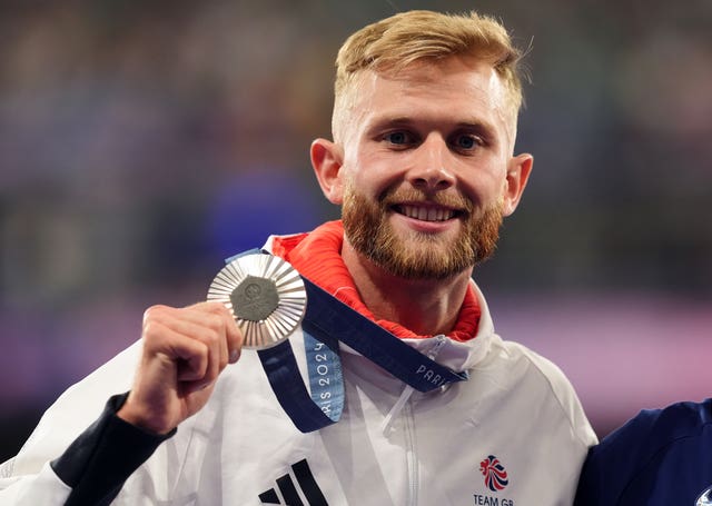 Josh Kerr celebrates with his Olympic silver medal