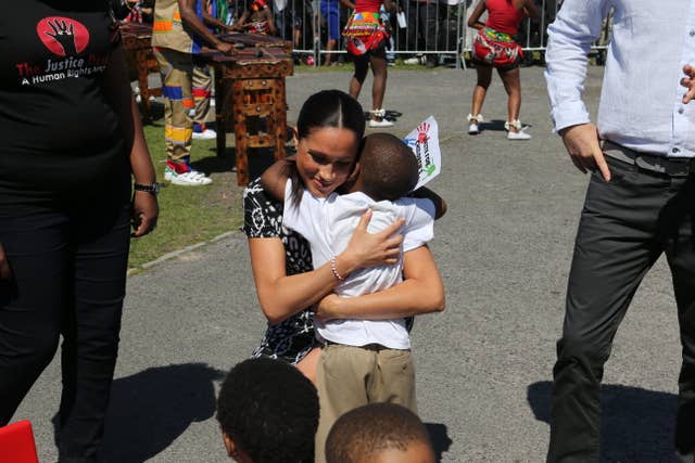 The Duchess of Sussex hugs a young child