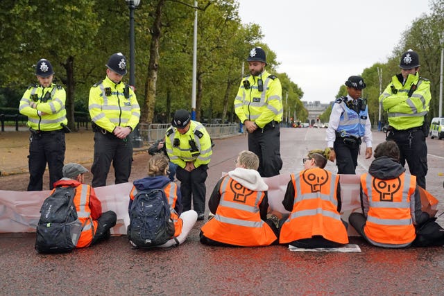 Police speak to campaigners from Just Stop Oil during a protest on The Mall, near Buckingham Palace (Jonathan Brady/PA)