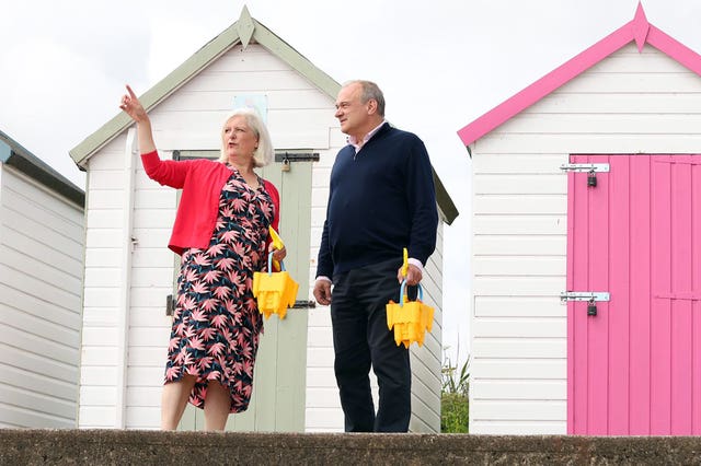 Liberal Democrats leader Sir Ed Davey with Liberal Democrats parliamentary candidate for South Devon Caroline Voaden stand in front of beach huts
