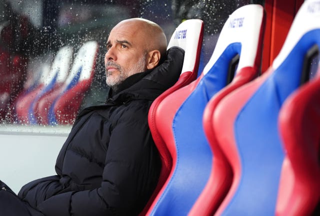 Pep Guardiola sits on the touchline at Selhurst Park 