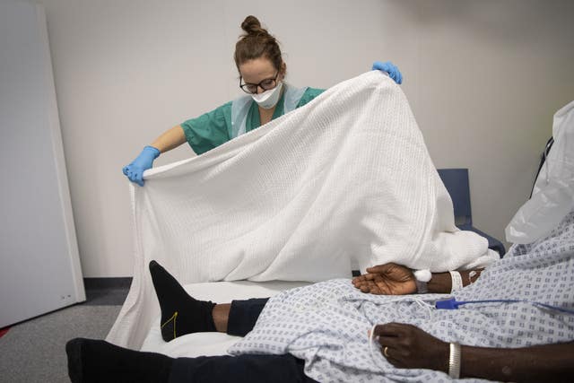 A staff nurse tends to a patient in the Emergency Department