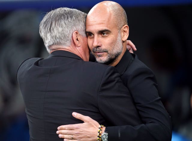 Manchester City boss Pep Guardiola, right, and Real Madrid manager Carlo Ancelotti  embrace