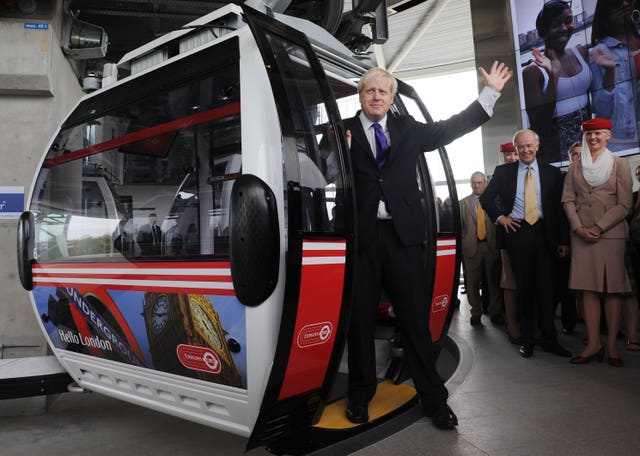 Then-London Mayor Boris Johnson takes one of the first rides on the Emirates Air Line cable car across the River Thames in London