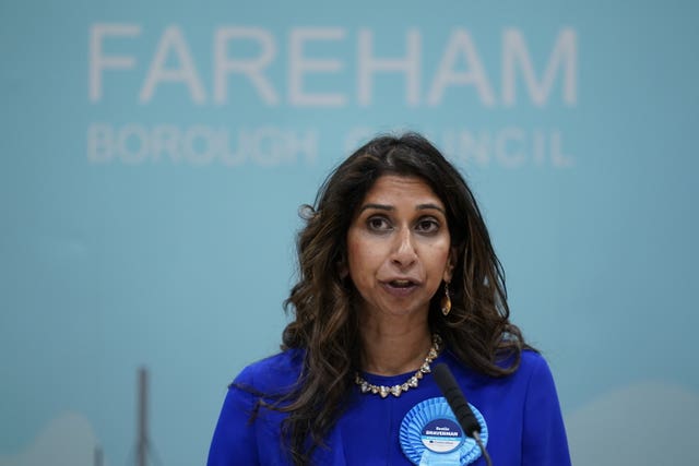 Suella Braverman on stage in front of blue background