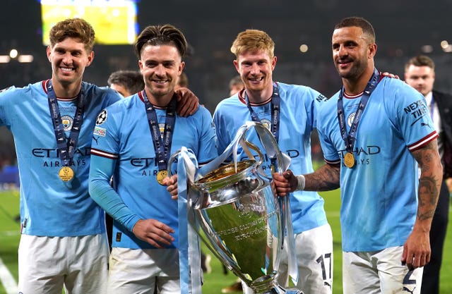 Manchester City’s John Stones (left), Jack Grealish, Kevin De Bruyne and Kyle Walker (right) with the UEFA Champions League trophy 