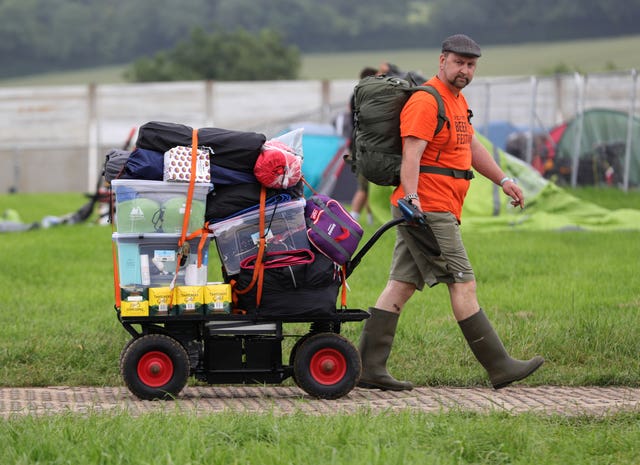 A man pulls a trolley load of festival essentials as he arrives on the first day of the Glastonbury Festival at Worthy Farm in Somerset