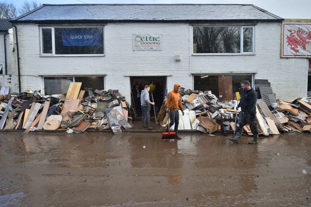 Staff members clean up outside the Celtic Flooring store in Nantgarw, South Wales 