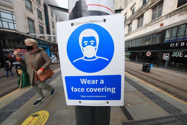 A sign advising on wearing face coverings at a tram stop in Manchester