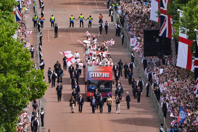 Buses carrying the England team make their way down the Mall
