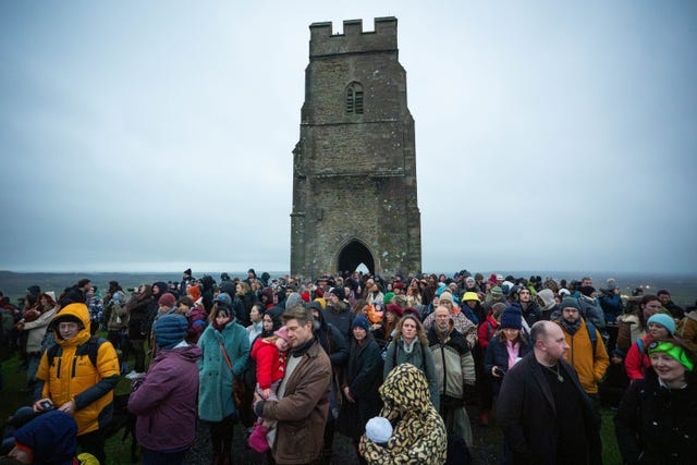 People take part in the winter solstice celebrations during sunrise at Glastonbury Tor in Somerset