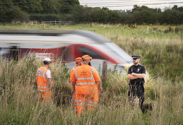 Police and railway workers near the scene in Balderton, near Newark-on-Trent 