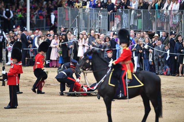 Medics help a soldier who fell from his horse during the ceremony