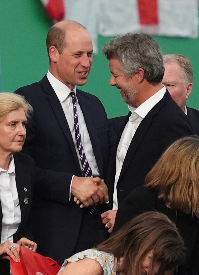 The Prince of Wales and King Frederik X of Denmark smile and shake hands in the stands after the Euro 2024 match between England and Denmark at the Frankfurt Arena