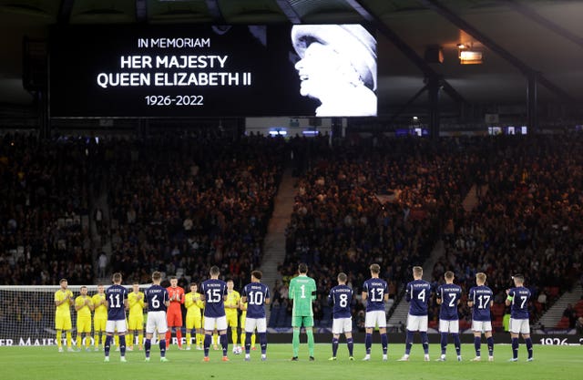 The players and fans take part in a minute''s applause for the Queen