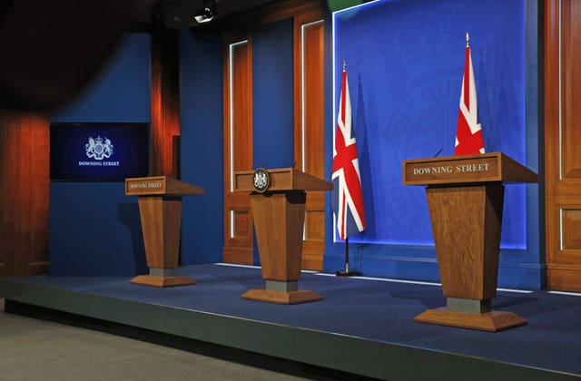 An empty stage with three podiums in the Downing Street press briefing room