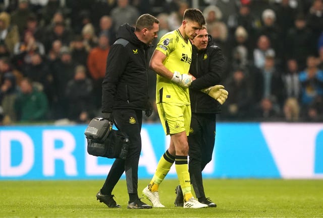 Newcastle goalkeeper Nick Pope (centre) is helped off 