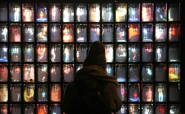A person looks at Supercube by Stephane Masson on display in St James’s Market (Jonathan Brady/PA)