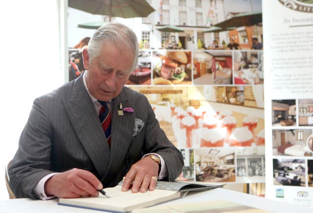As then-Prince of Wales, Charles signed a book of his watercolours which were to be auctioned for charity (Steve Parsons/PA)