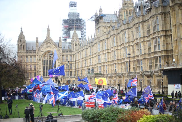 Photo taken in January of anti-Brexit and Pro-Brexit protesters flying flags outside the Houses of Parliament (Yui Mok/PA)