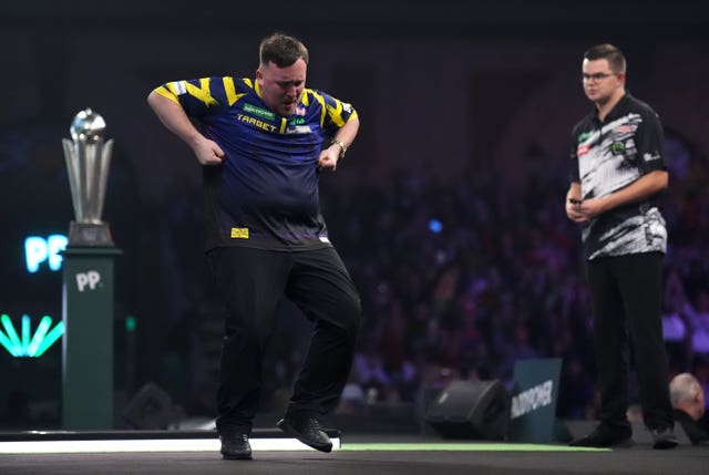 Luke Littler celebrates on stage