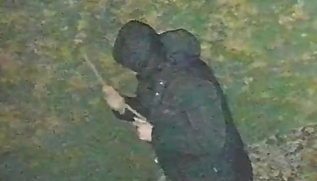 CCTV image of John Ashby holding a stick