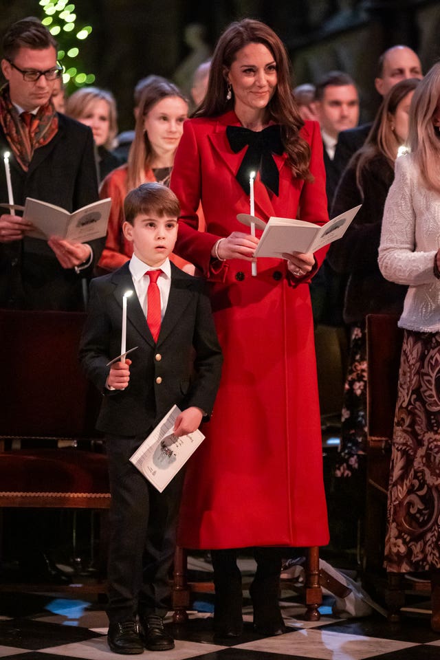 Prince Louis and the Princess of Wales hold candles during the Together At Christmas carol service at Westminster Abbey in London