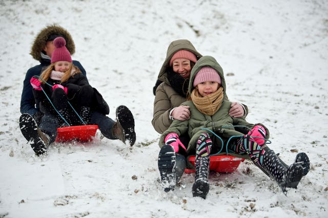 A group of people ride sledges in the snow in Essex