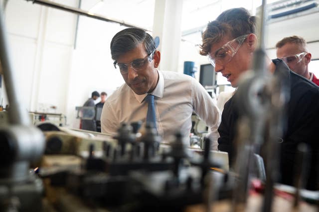 Prime Minister Rishi Sunak wearing goggles watching a demonstration of some machinery during a visit to Silverstone University Technical College in Towcester, Northamptonshire