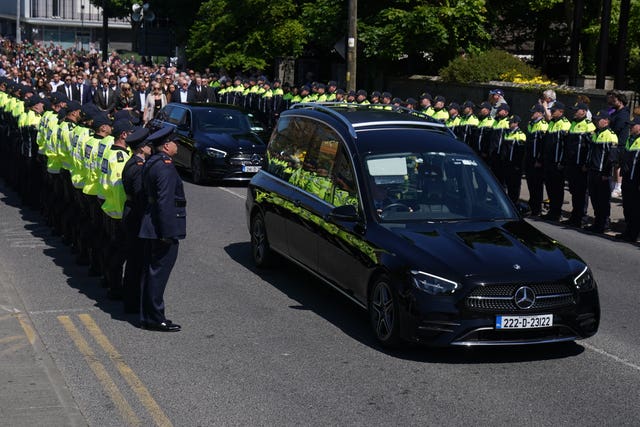 Garda line up in a guard of honour as the hearse travels past for Kevin Flatley's funeral
