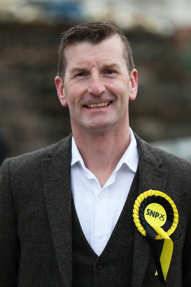 Dave Doogan smiling, wearing an SNP rosette