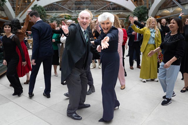 Sir Lindsay Hoyle, centre left, and Angela Rippon, centre right, posing with their arms out stretched in front of other dancing MPs and celebrities including Dame Arlene Phillips, Hannah Spencer and Flavia Cacace