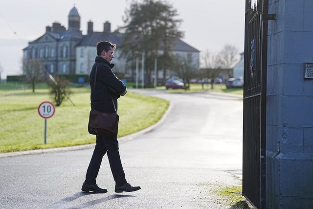 Enoch Burke standing outside, with a large building in the background