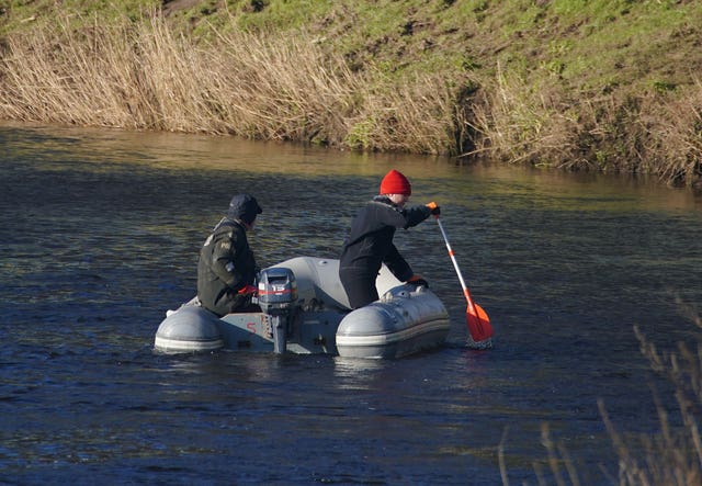 Specialist search officers drive a boat along the River Wyre