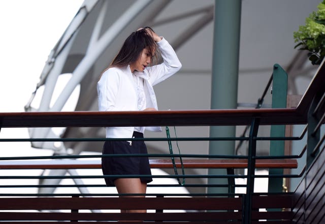 Emma Raducanu walking across a bridge inside the Wimbledon grounds looking disappointed