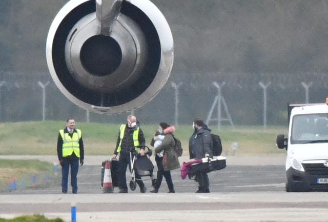 Passengers from a plane carrying British nationals from the coronavirus-hit city of Wuhan in China, walk from the aircraft after it landed at RAF Brize Norton in Oxfordshire in late January 2020