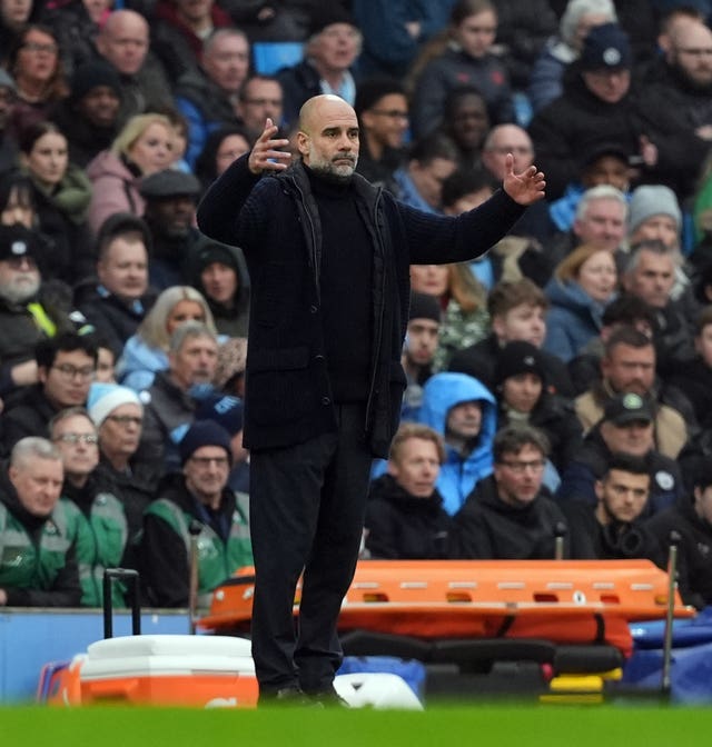 Manchester City manager Pep Guardiola raises his arms on the touchline