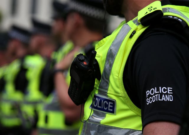 A row of Police Scotland officers, wearing uniform including hi-viz vests